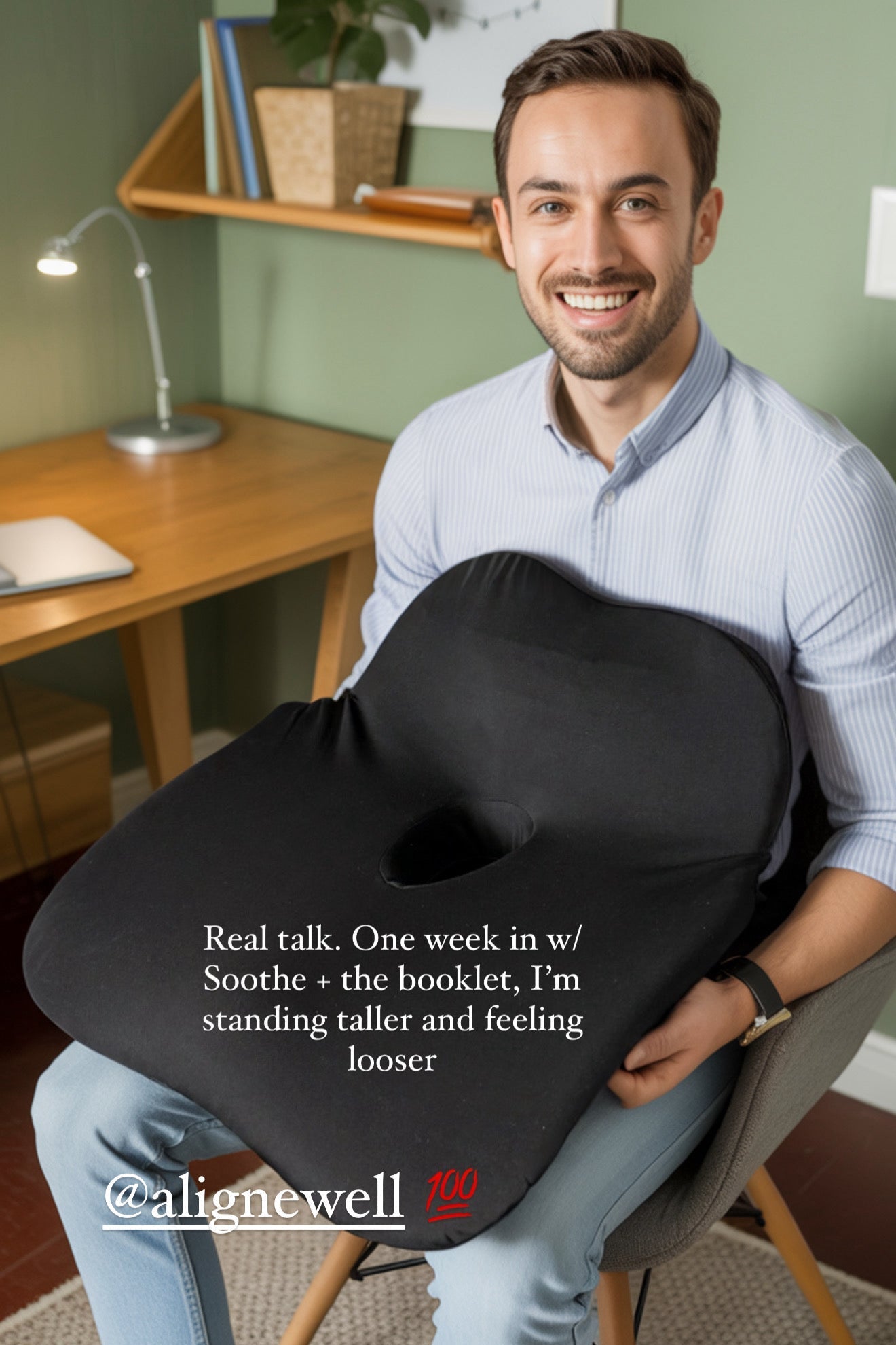 Man sitting on a chair with a black posture cushion, smiling, in a home office setting.