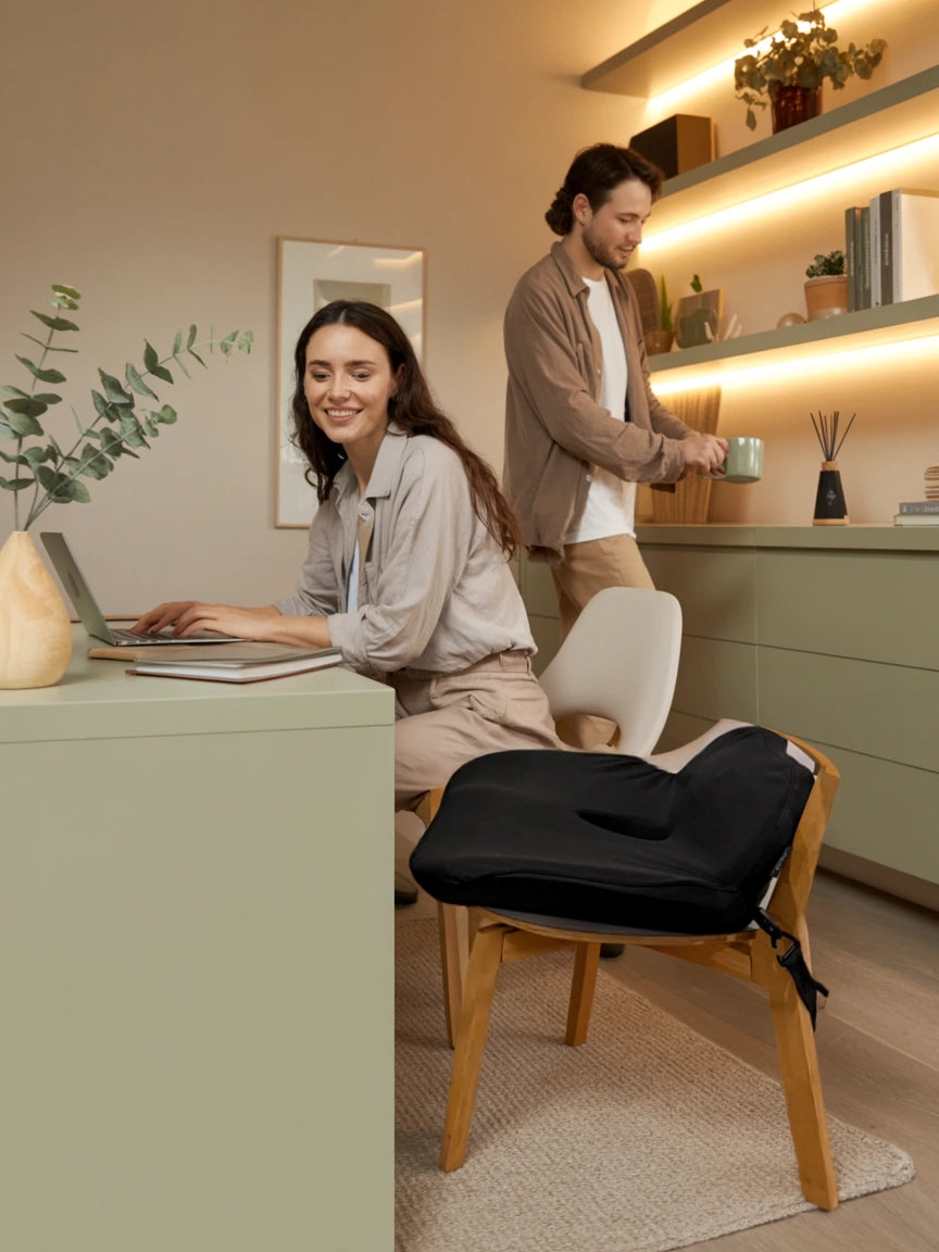 A calming sunlit home office with a black posture cushion, Soothe, on a chair